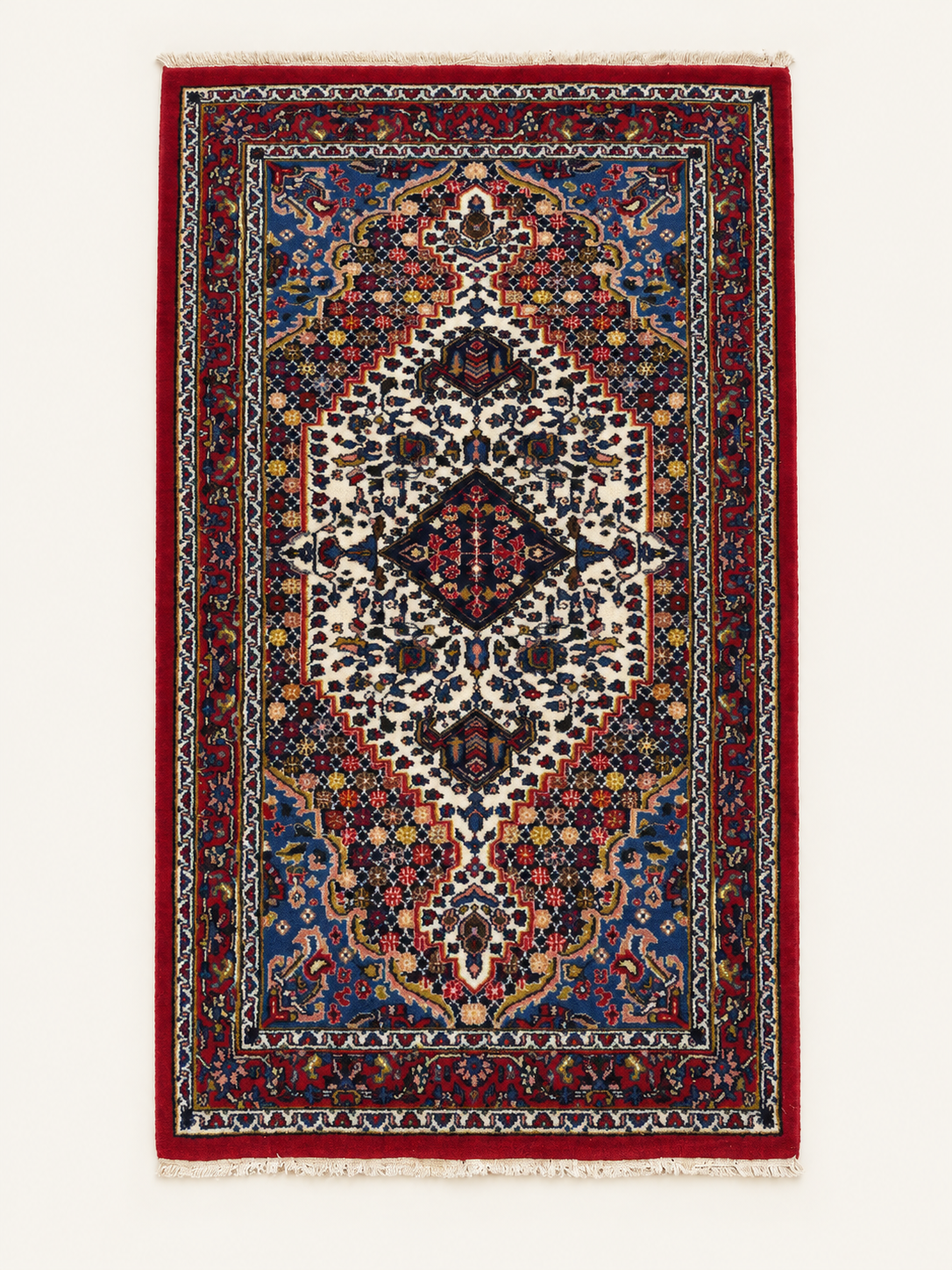 Handgeknüpfter Orientteppich mit rotem Bordüre, blauen Medaillons und beiger Fransung